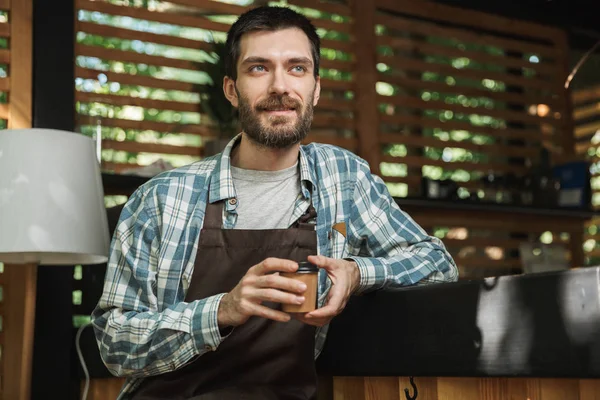 Imagem do garçom animado sentado no bar enquanto trabalhava em — Fotografia de Stock