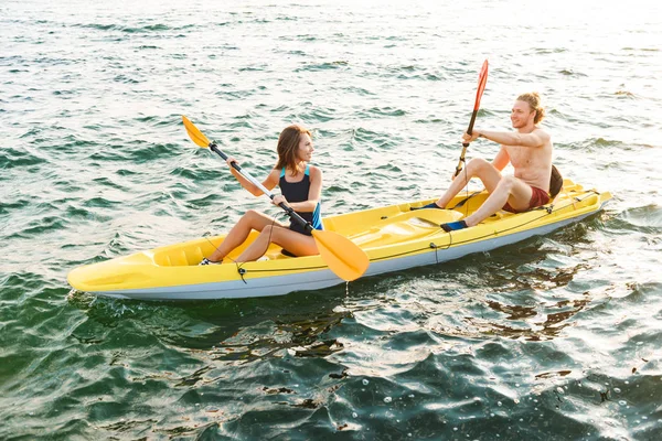 Sportigt attraktivt par kajakpaddling — Stockfoto