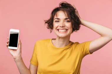 Mutlu genç güzel kadın cep telefonu kullanarak pembe duvar arka plan üzerinde izole poz.