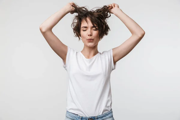 Imagen de la mujer sonriente en camiseta básica tocando su pelo y lo —  Fotos de Stock