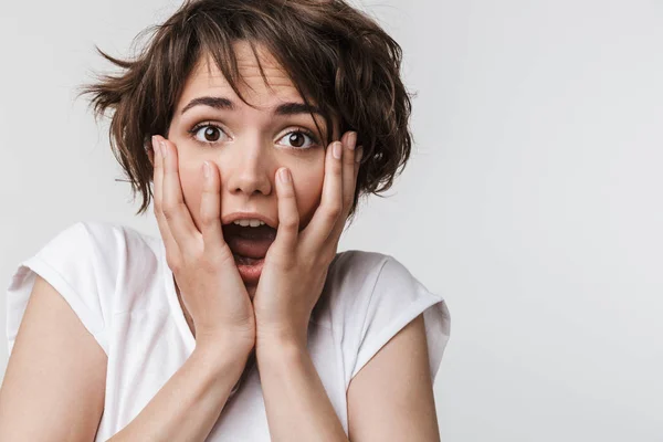 Foto einer schockierten Frau mit kurzen braunen Haaren im einfachen T-Shirt — Stockfoto