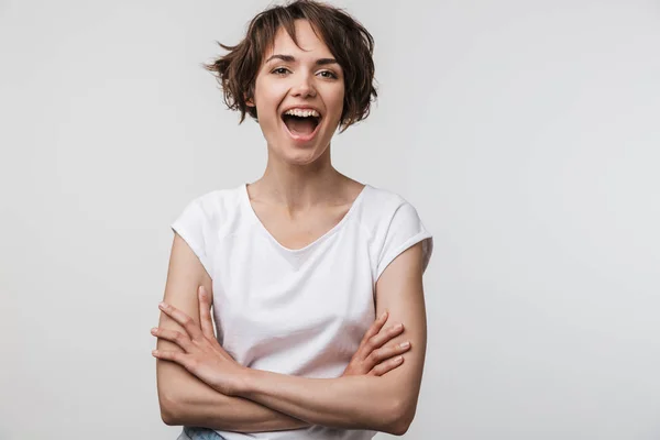 Imagem da jovem mulher em camiseta básica sorrindo para a câmera enquanto st — Fotografia de Stock