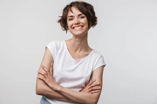 Imagen de la mujer alegre en camiseta básica sonriendo a la cámara mientras —  Fotos de Stock