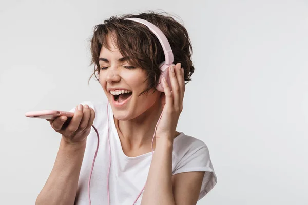 Bild av glada kvinna i grundläggande t-shirt sjunger medan du lyssnar t — Stockfoto