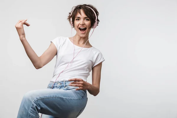 Bild av vacker kvinna i grundläggande t-shirt spelar osynlig gitarr — Stockfoto