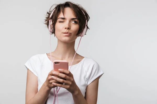 Imagem de mulher atraente em t-shirt básica segurando smartphone wh — Fotografia de Stock