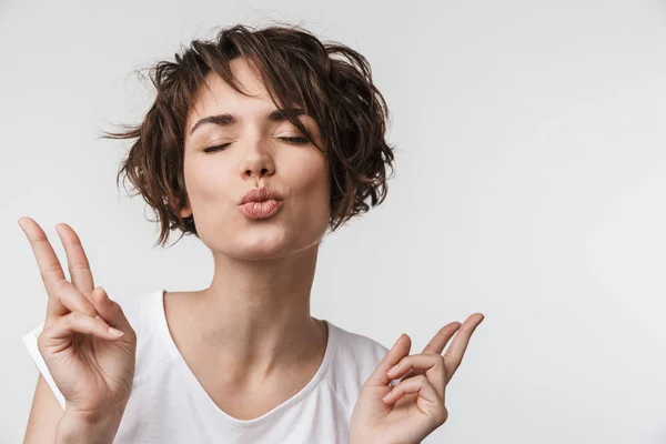 Excited happy woman posing isolated over white wall background showing peace gesture. — Stock Photo, Image