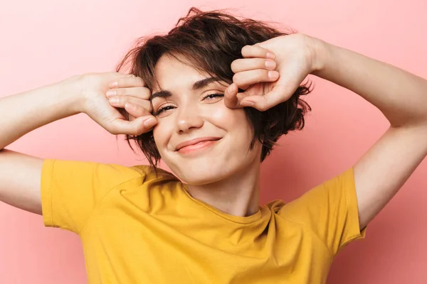 Agradable hermosa mujer posando aislado sobre fondo de pared rosa que se extiende por la mañana . —  Fotos de Stock