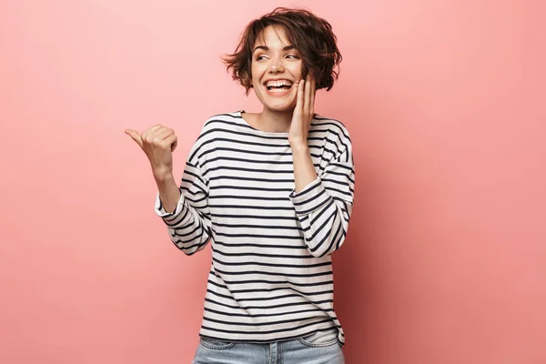 Emocionada sorprendida mujer hermosa posando aislada sobre fondo de pared rosa señalando . —  Fotos de Stock