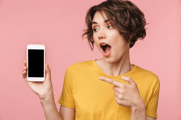 Megdöbbentett fiatal szép nő jelentő elszigetelt több mint rózsaszín fal háttér segítségével a mobil telefon. — Stock Fotó