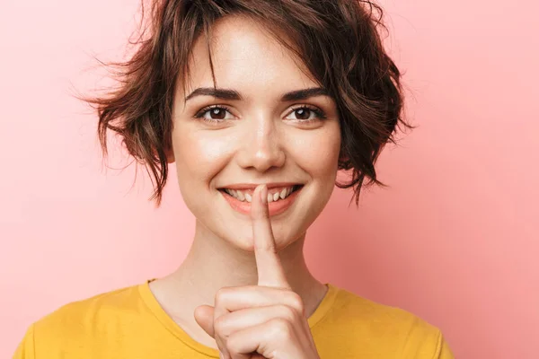 Feliz hermosa mujer posando aislada sobre fondo de pared rosa mostrando gesto de silencio . —  Fotos de Stock