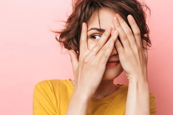 Joven divertida hermosa mujer posando aislada sobre la pared rosa de fondo cubriendo la cara . — Foto de Stock