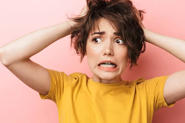 Bang verward mooie vrouw poseren geïsoleerd over roze muur achtergrond. — Stockfoto