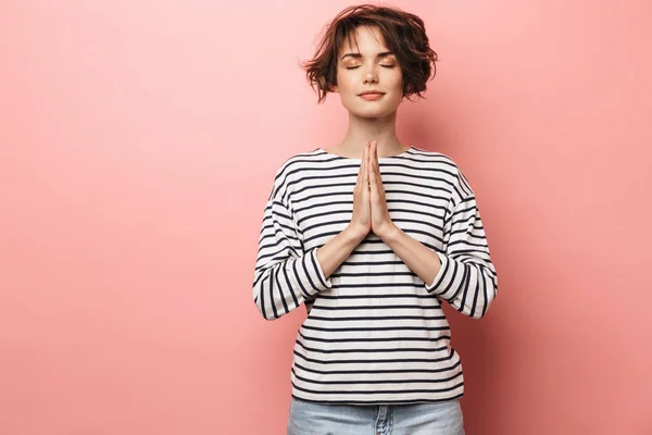 Agradable hermosa mujer posando aislada sobre fondo de pared rosa meditar . — Foto de Stock