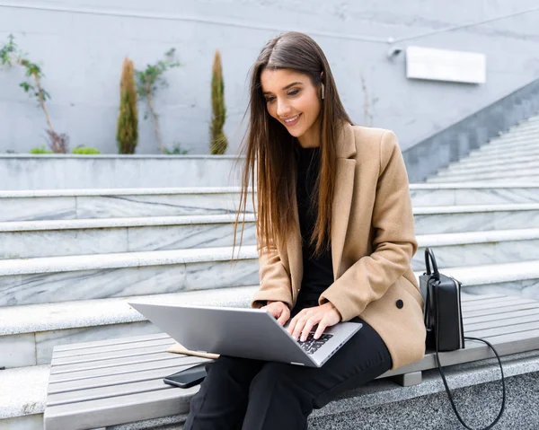 Schöne junge Frau trägt Herbstmantel mit Laptop — Stockfoto