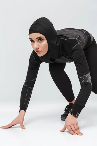 Mulher fitness muçulmano fazendo exercício isolado sobre fundo da parede branca — Fotografia de Stock