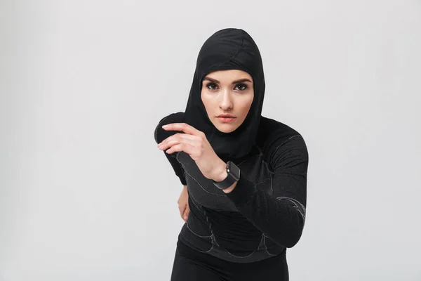 Женщина фитнес-мусульманин делает упражнения изолированы на белом фоне стены — стоковое фото