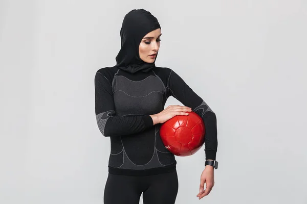 Женщина фитнес-мусульманин делать упражнения с мячом изолированы на белом фоне стены . — стоковое фото