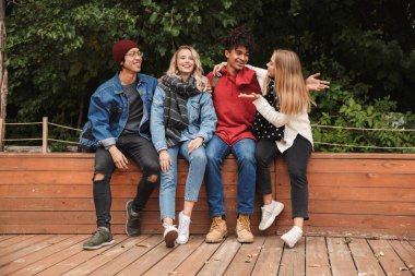 Mutlu multhietnic arkadaşlar birlikte dışarı asılı