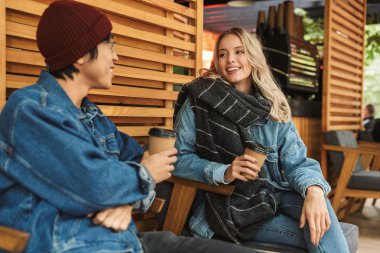 Gülümseyen multhiethnic çift açık havada kafede sitititng