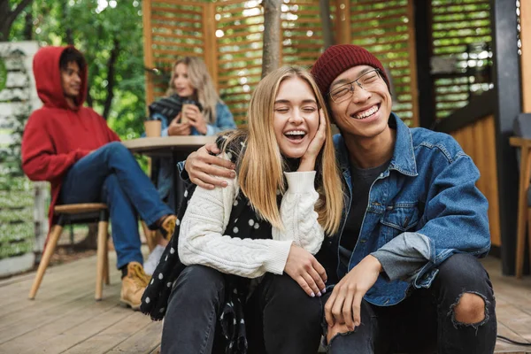 Veselý multhietnický pár, který sedí pohromadě — Stock fotografie