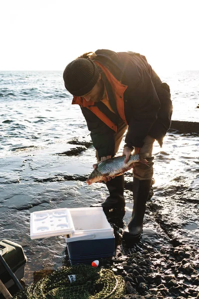 Primo piano di un pescatore che mette pesce pescato — Foto Stock