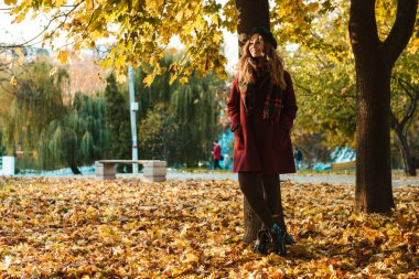 Güzel genç güzel kadın sonbahar bahar parkı açık havada yürüyüş.