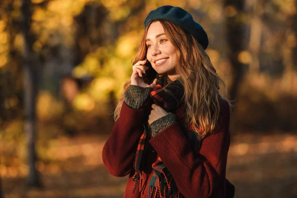 Vacker lycklig ung vacker kvinna som går utomhus i höst vår Park pratar med mobiltelefon. — Stockfoto