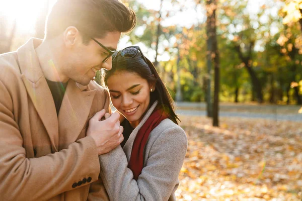 Изображение молодой счастливой пары, улыбающейся и обнимающейся осенью — стоковое фото