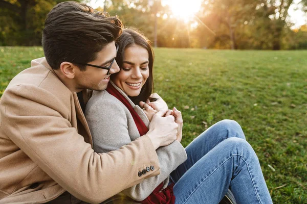 Image of brunette caucasian couple smiling and hugging each other in park — Stock Photo, Image