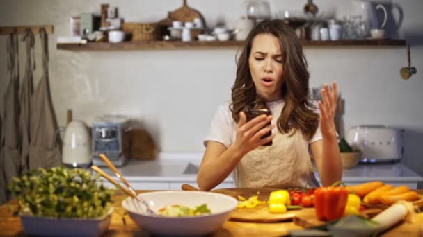 Νεαρή Όμορφη Κυρία Λαμβάνει Άσχημα Νέα Στο Τηλέφωνο Ενώ Μαγείρεμα — Αρχείο Βίντεο