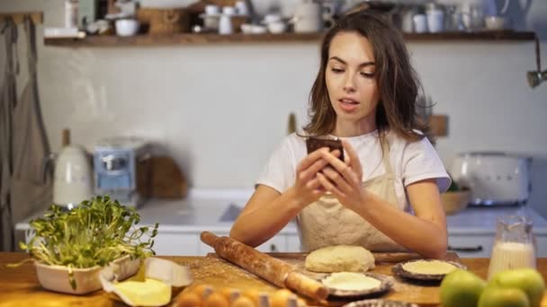 Sorridente Signorina Grembiule Chatta Sullo Smartphone Mentre Cucina Cucina — Video Stock