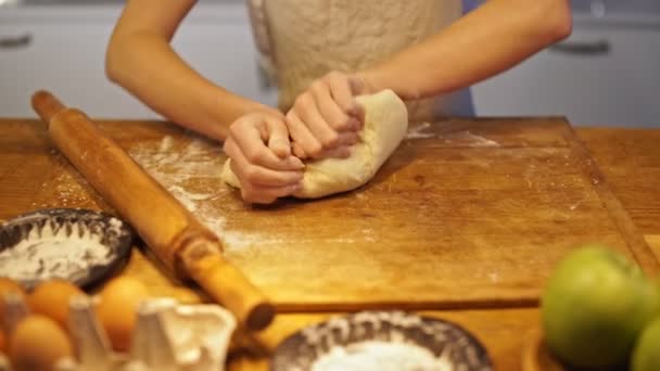 台所でアップルパイのためのエプロン混練生地で若いかわいい女性のクローズアップビュー — ストック動画