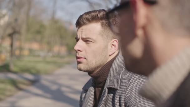 Zwei Gut Aussehende Erwachsene Männer Sprechen Während Sie Morgens Park — Stockvideo