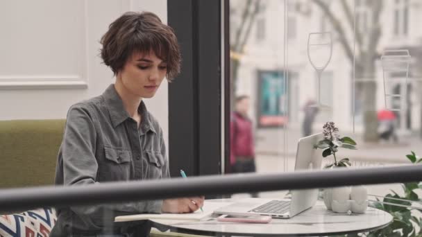 Bonita Joven Escribiendo Bloc Notas Sentada Café — Vídeos de Stock