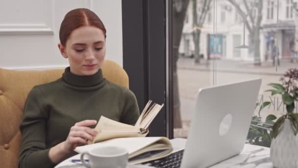 Ganska Ung Redhair Kvinna Lärande Och Göra Anteckningar Sitter Kaféet — Stockvideo