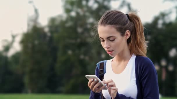 Mujer Morena Sorprendido Sentado Hierba Uso Teléfono Inteligente Parque — Vídeos de Stock