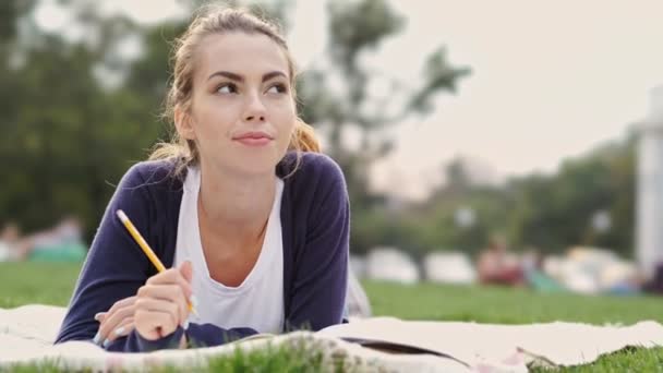 Mujer Morena Sonriente Pensativa Acostada Hierba Escribiendo Algo Cuaderno Parque — Vídeos de Stock