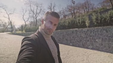 Parkta selfie çeken güzel yetişkin adam