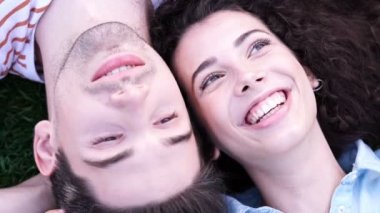 Mutlu romantik çift çimenler üzerinde yatıyor ve birbirleriyle konuşuyor