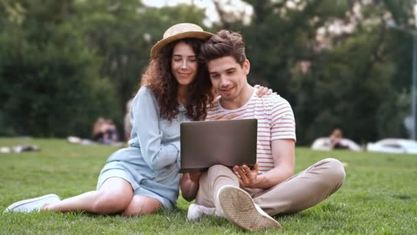 Mutlu Romantik Çift Çim Üzerinde Oturan Dizüstü Bilgisayar Kullanarak — Stok video