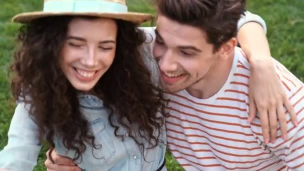 Χαρούμενο Ρομαντικό Ζευγάρι Κάθεται Στο Γρασίδι Και Πάρει Μια Selfie — Αρχείο Βίντεο