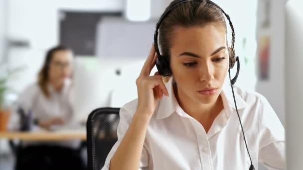 Genç Ciddi Kadını Mikrofon Konuşma Ile Bilgisayar Kulaklık Kullanarak Ofiste — Stok video
