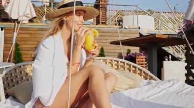 Yaz hasır şapka muhteşem sarışın kadın 20s plajda kokteyl içme bir dinlenme var