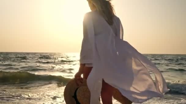 ビーチで屋外を歩く夏のわら帽子でブロンド女性20代 — ストック動画
