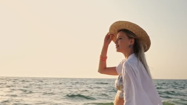 华丽的金发女郎 20S 在夏天草帽走户外的海滩 — 图库视频影像