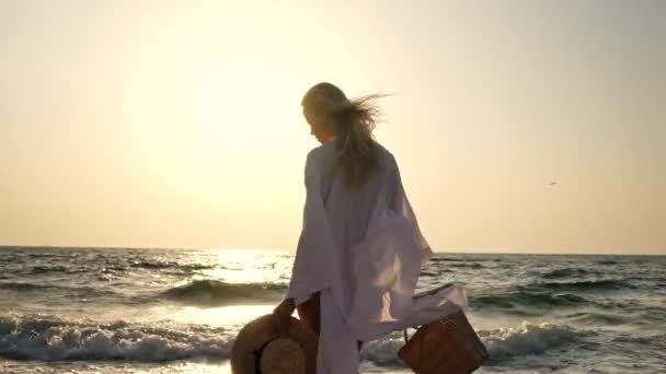 ビーチで屋外を歩く夏のわら帽子で美しいブロンドの女性20代 — ストック動画