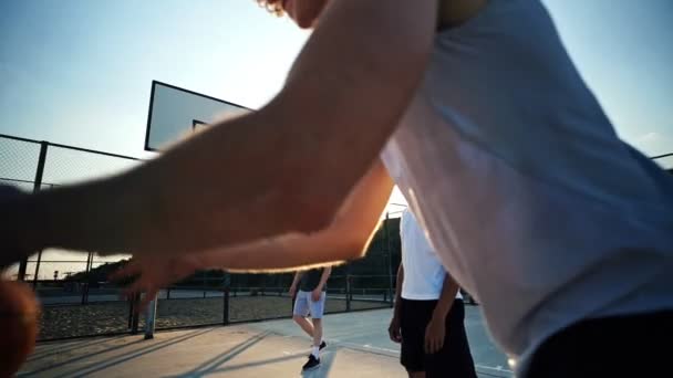 遊び場で一緒にバスケットボールをしている陽気な4人の多民族の友人 — ストック動画