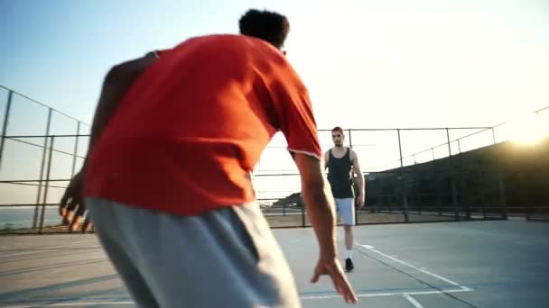 遊び場で一緒にバスケットボールをしている4人の多民族の友人を集中 — ストック動画