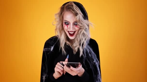 Femme Gaie Magicien Portant Costume Noir Maquillage Halloween Utilisant Smartphone — Video